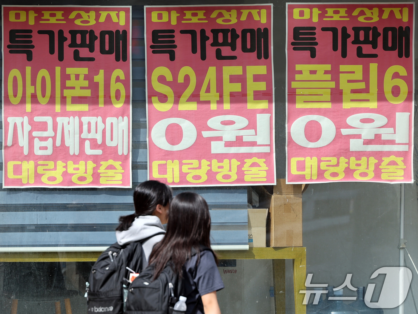 (서울=뉴스1) 황기선 기자 = '이동통신단말장치 유통구조 개선에 관한 법률'(단통법) 폐지를 이틀 앞둔 20일 오후 서울 시내 한 핸드폰 매장앞에서 시민들이 이동하고 있다.단통법 …