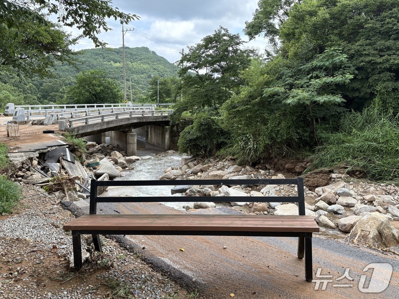 본문 이미지 - 계곡 옆 무너진 도로에 떠내려 온 벤치.2025.07.20/뉴스1 강미영기자