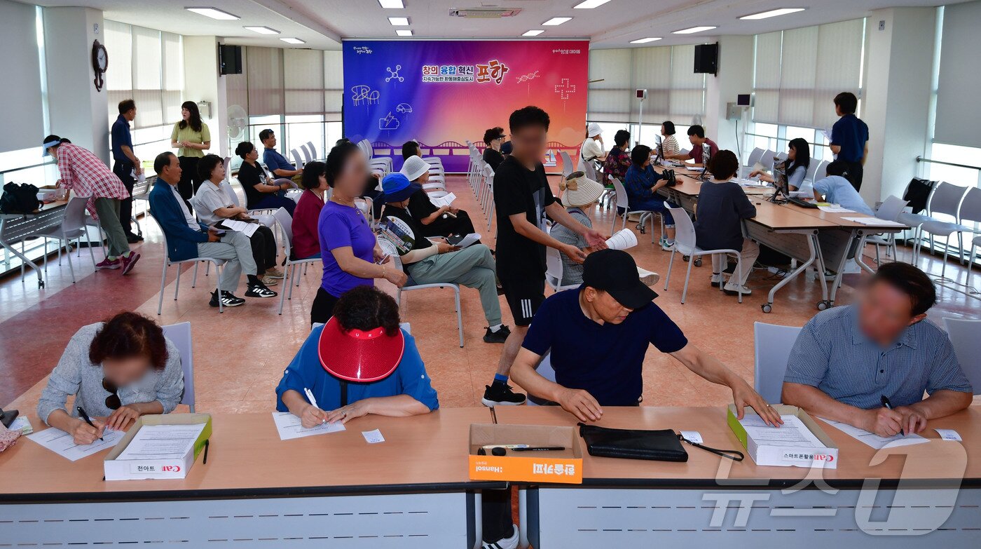 본문 이미지 - 민생회복 소비쿠폰 신청 첫 날인 21일 오전 경북 포항시 남구 대이동 행정복지센터 2층에서 시민들이 신청서를 작성하고 있다. 2025.7.21/뉴스1 ⓒ News1 최창호 기자