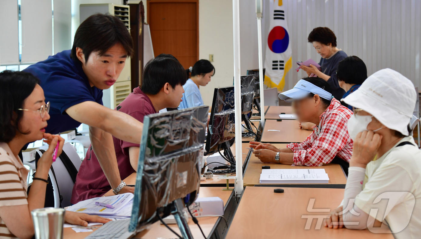 (포항=뉴스1) 최창호 기자 = 민생회복 소비쿠폰 신청 첫 날인 21일 오전 경북 포항시 남구 대이동 행정복지센터 2층에서 시민들이 신청하고 있다. 2025.7.21/뉴스1