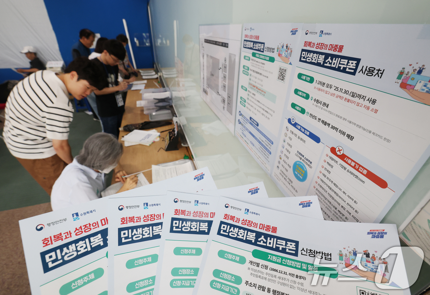 (수원=뉴스1) 김영운 기자 = '민생회복 소비쿠폰'의 1차 신청 첫날인 21일 오전 경기 수원시 팔달구 인계동행정복지센터에서 시민들이 신청서를 작성하고 있다. 2025.7.21/ …