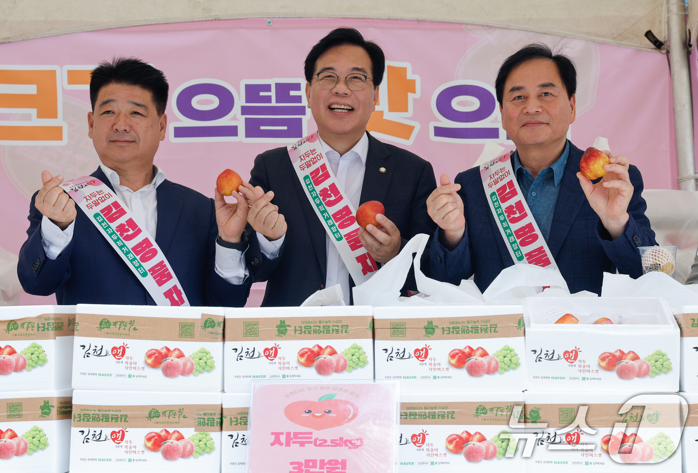 (서울=뉴스1) 안은나 기자 = 송언석 국민의힘 비상대책위원장 겸 원내대표(가운데)가 21일 서울 여의도 국회 소통관 앞에서 열린 김천 자두 홍보·판촉 행사장을 찾아 배낙호 김천시 …