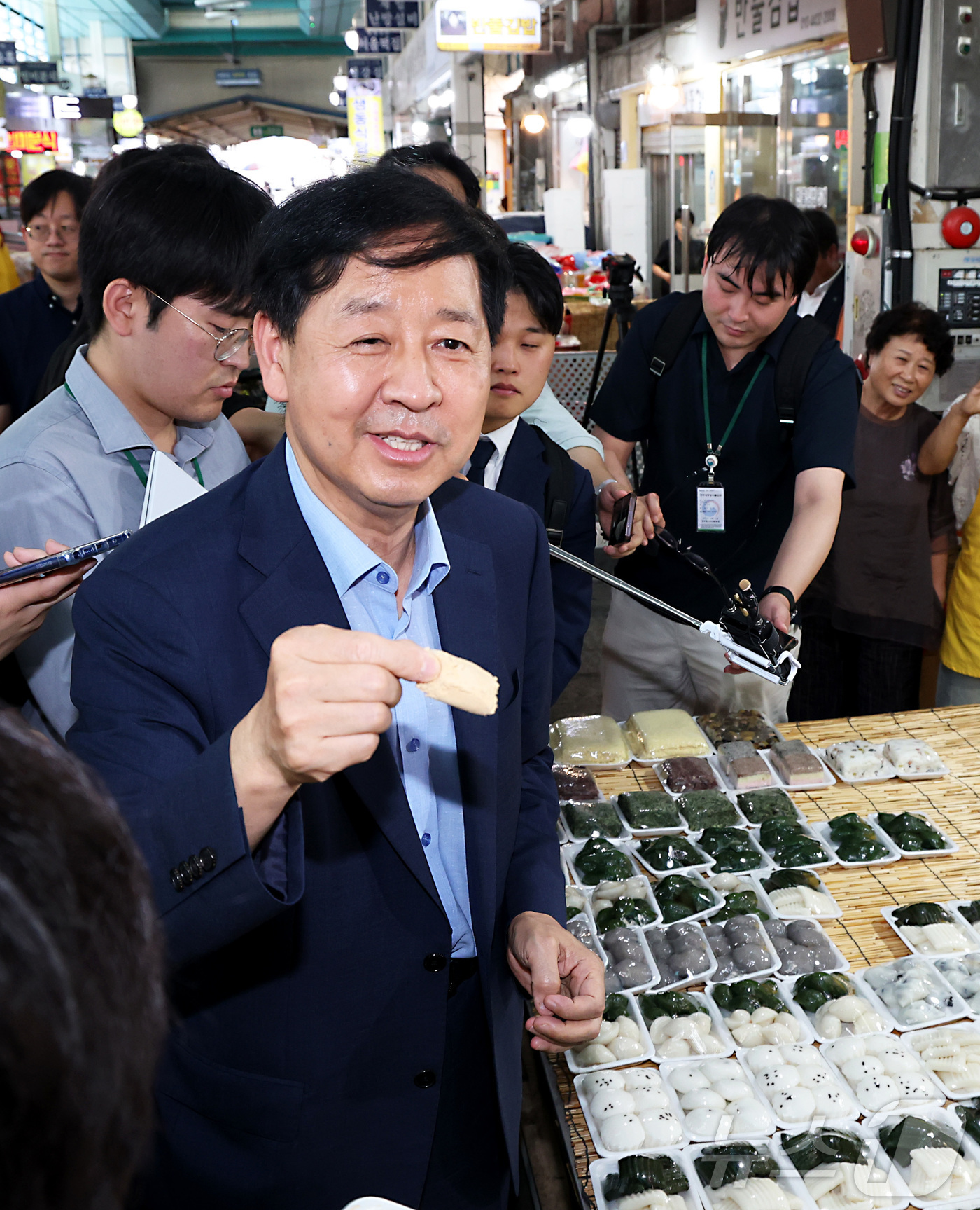 (세종=뉴스1) 김기남 기자 = 구윤철 경제부총리 겸 기획재정부 장관이 21일 오후 민생회복 소비쿠폰 시행 첫날 충남 공주시 산성시장을 방문 떡집을 방문하여 인절미를 시식하며 시민 …