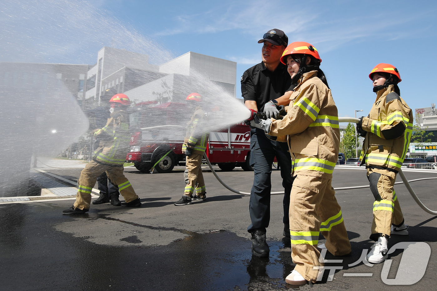 (대구=뉴스1) 공정식 기자 = 22일 대구 동구 대구소방교육안전센터에서 열린 한국119청소년단 소방안전체험에 참여한 중학생들이 방화복을 착용하고 방수훈련을 하고 있다. 2025. …