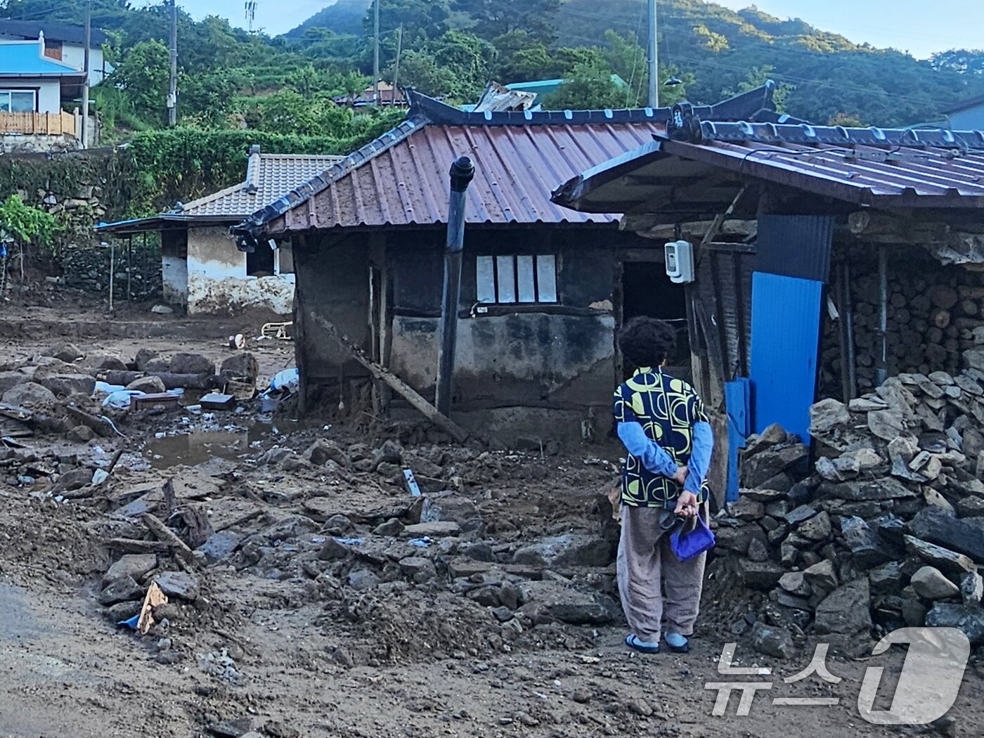 본문 이미지 - 22일 경남 산청군 율현마을 산사태 실종자의 아내 전인호 씨&#40;74&#41;가 자신의 집과 주변을 살펴보며 실종된 남편을 찾고 있다. 2025.7.22/뉴스1 ⓒ News1 한송학 기자