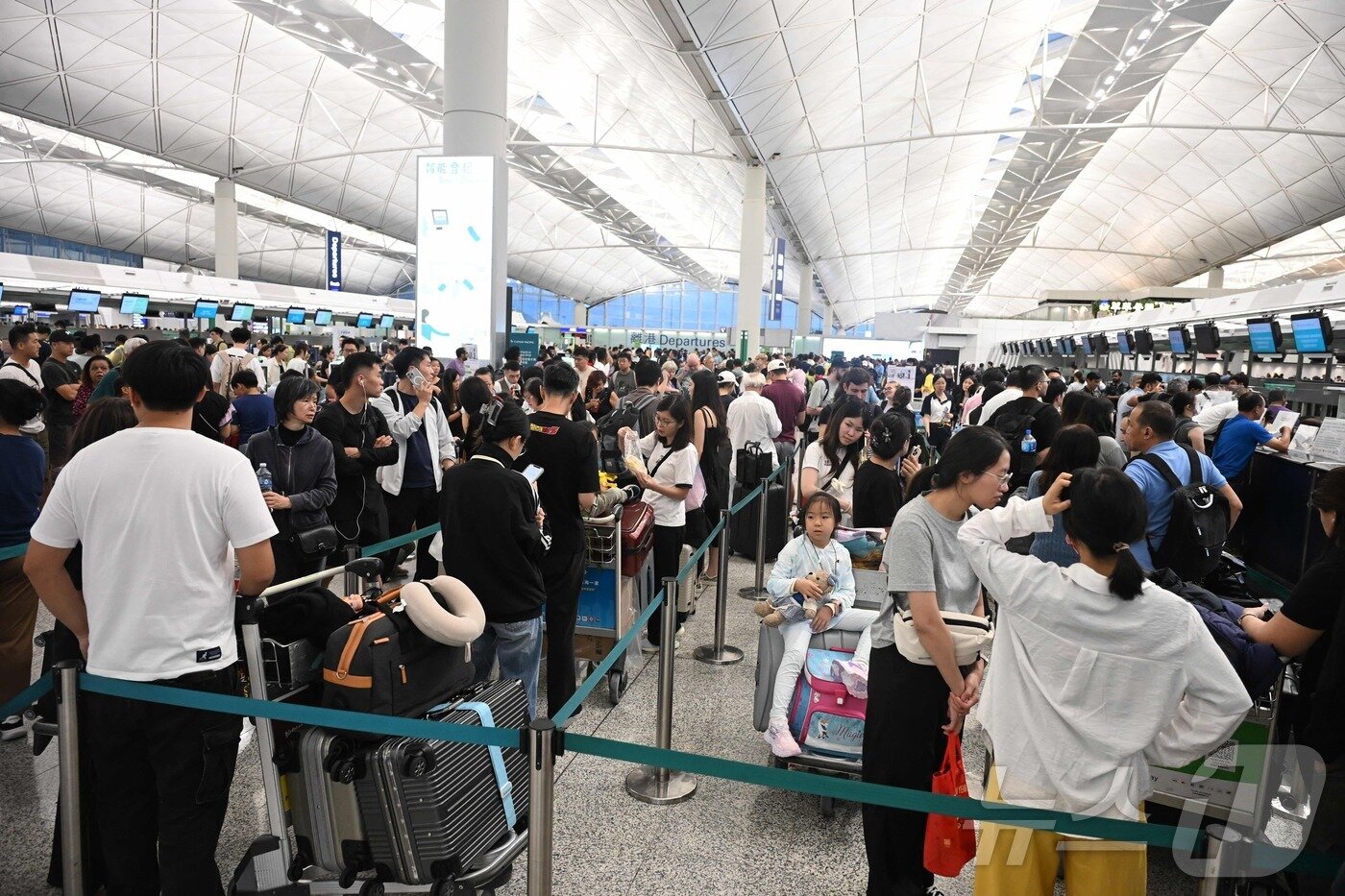 본문 이미지 - 20일 태풍 위파가 홍콩을 지나는 동안 홍콩 국제공항에서 출국 승객들이 탑승 수속을 위해 길게 줄을 서고 있다. 홍콩공항관리국에 따르면, 기상 악화로 인해 약 500편의 항공편이 취소됐으며, 이후 당일 중 약 400편의 항공기가 이륙하거나 착륙할 예정이다.2025.07.20.ⓒ AFP=뉴스1