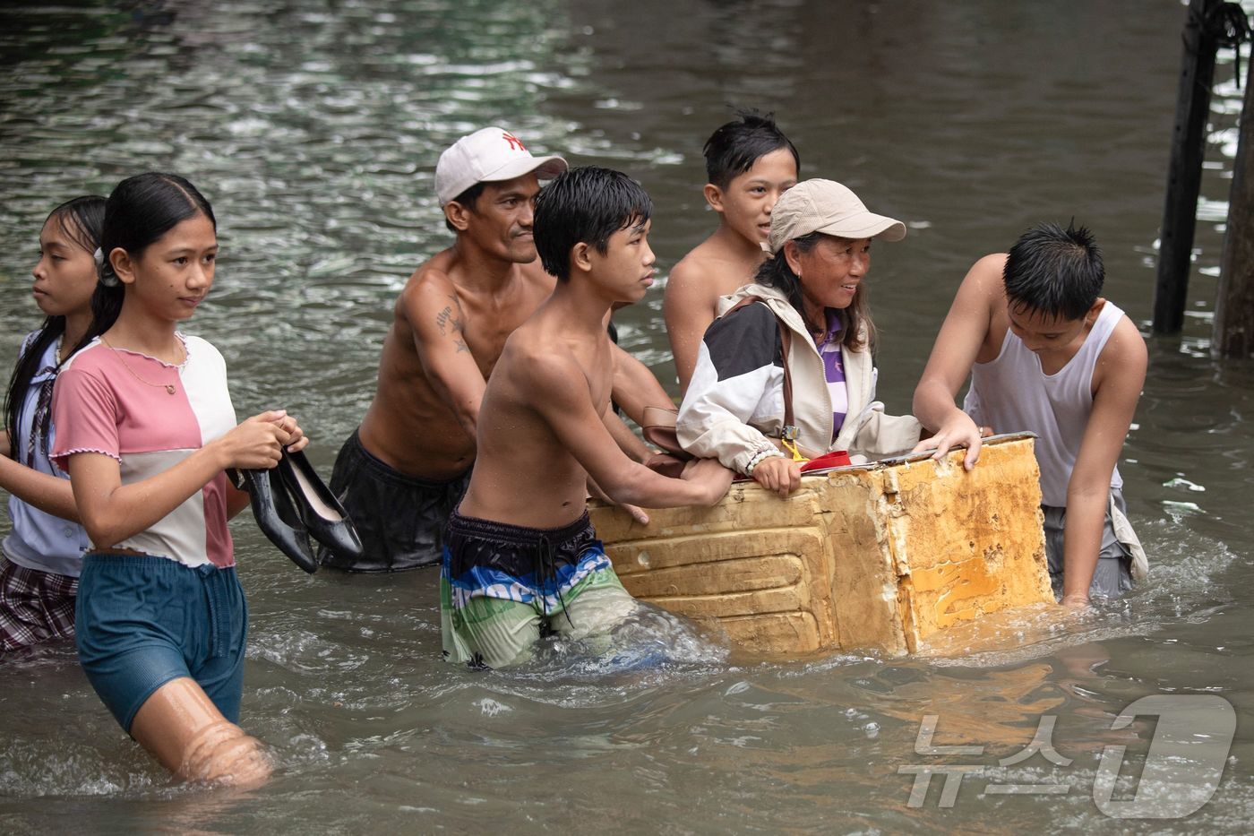 본문 이미지 - 21일 태풍 위파의 영향으로 폭우와 홍수가 발생한 필리핀 마닐라에서 주민들이 물에 잠긴 거리를 스티로폼 박스까지 동원해 이동하고 있다.2025.07.21. ⓒ AFP=뉴스1