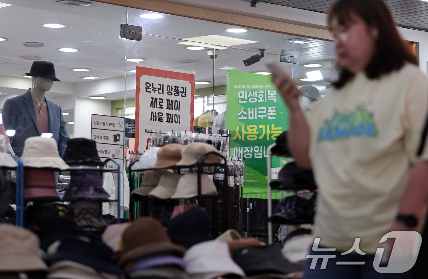 (서울=뉴스1) 김성진 기자 = 민생회복 소비쿠폰 1차 신청 둘째 날인 22일 서울 강동구 암사종합시장 내 옷가게에 지원금 사용 가능 안내문이 붙어 있다.민생회복 소비쿠폰은 신청 …