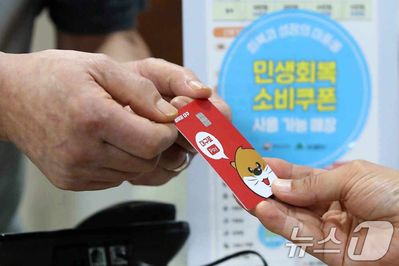 본문 이미지 - 22일 대구 중구의 한 음식점에서 식사를 마친 시민이 민생회복 소비쿠폰이 입금된 대구사랑상품권&#40;대구로페이&#41; 카드로 식대를 결제하고 있다. 2025.7.22/뉴스1 ⓒ News1 공정식 기자