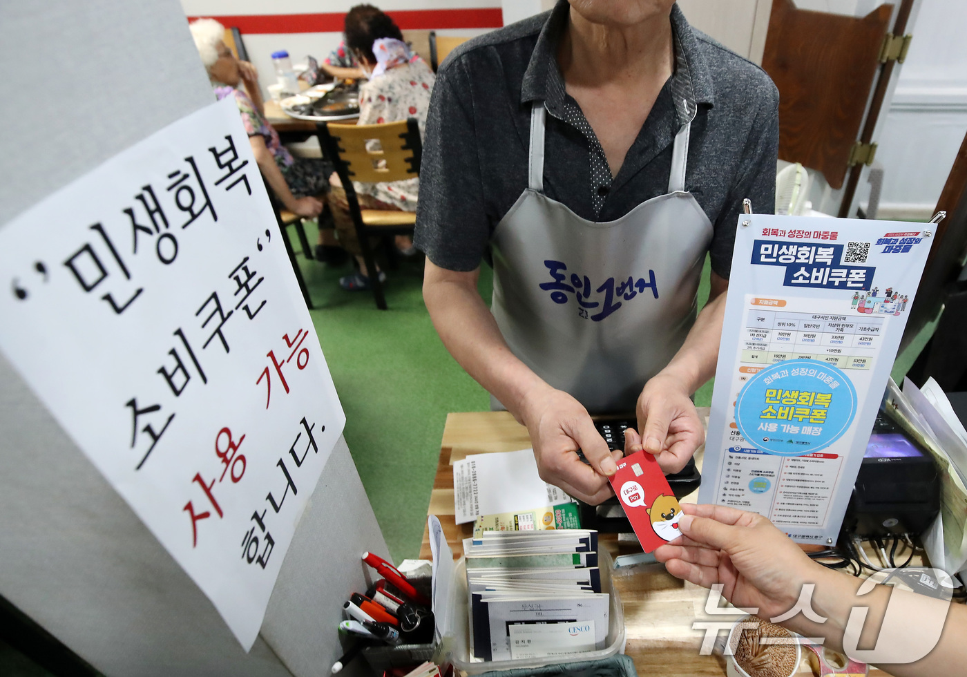 (대구=뉴스1) 공정식 기자 = 22일 오후 대구 중구의 한 음식점에서 식사를 마친 시민이 민생회복 소비쿠폰이 입금된 대구사랑상품권(대구로페이) 카드로 식대를 결제하고 있다. 20 …