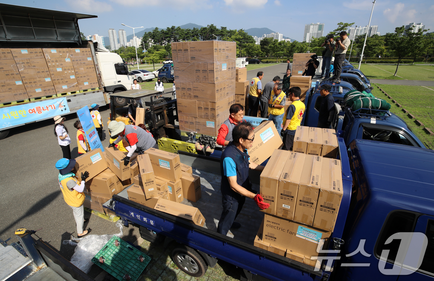 (부산=뉴스1) 윤일지 기자 = 전국 대부분 지역에 폭염특보가 발효 중인 23일 오전 부산진구 부산시민공원 야외주차장에서 대한적십자사 부산지사 자원봉사원들이 취약계층에 전달할 선풍 …