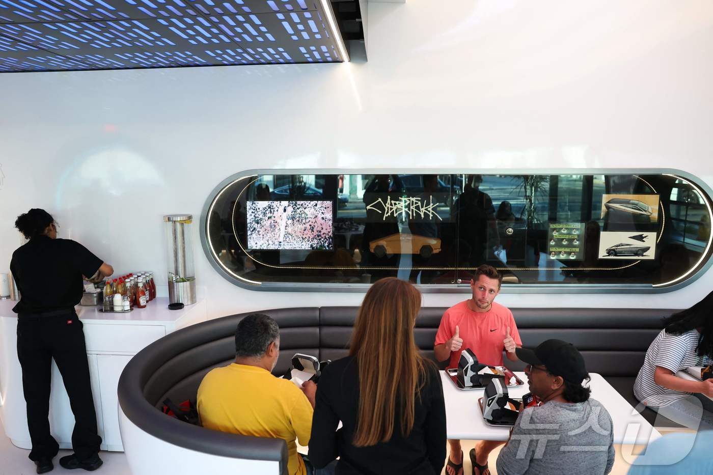 본문 이미지 - 21일&#40;현지시간&#41; 미국 캘리포니아주 로스앤젤레스 할리우드 지역 산타모니카 블러버드에서 테슬라 다이너가 개장해 고객들이 사이버트럭 모양의 상자에 담긴 음식을 먹고 있다. 2025.07.21.ⓒ AFP=뉴스1