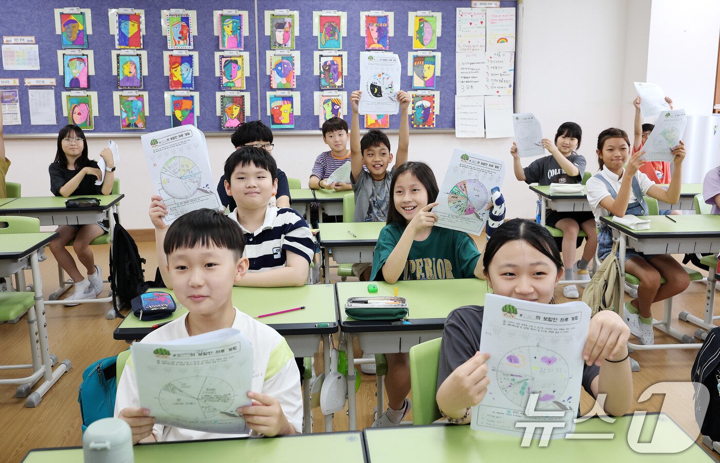 본문 이미지 - 23일 서울 동작구 삼일초등학교에서 열린 여름 방학식에서 학생들이 여름방학 계획표를 들어보이며 기뻐하고 있다. 2025.7.23/뉴스1 ⓒ News1 박지혜 기자