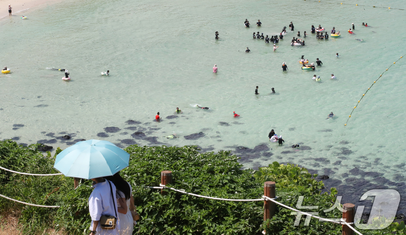 (제주=뉴스1) 오현지 기자 = 제주도 북부·남부·동부·서부·북부중산간에 폭염주의보가 내려진 23일 오전 제주시 조천읍 함덕해수욕장에서 피서객들이 더위를 쫓고 있다. 2025.7. …