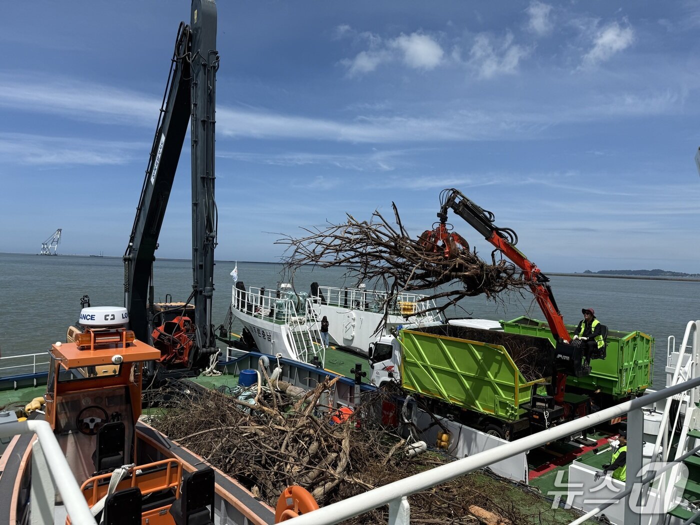 본문 이미지 - 전북도와 충남도가 각각이 소유 중인 정화선과 운반선을 활용해 집중호우로 유입된  해양폐기물(부유 쓰레기)을 공동 수거하고 있다.(전북도 제공. 재판매 및 DB금지)/뉴스1