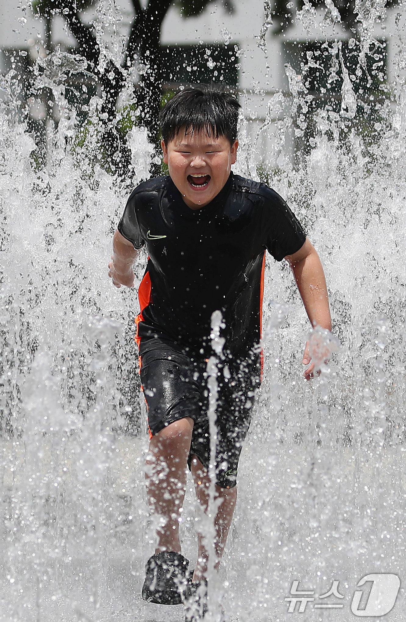 (대구=뉴스1) 공정식 기자 = 오전부터 폭염이 시작된 23일 대구 서구 서부도서관 앞 평리공원 바닥분수에서 어린이가 물줄기 속으로 뛰어들어 찜통더위를 식히고 있다. 2025.7. …