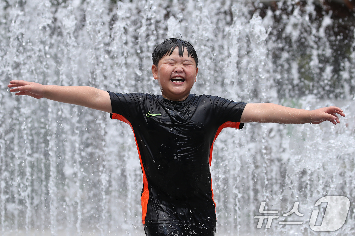 (대구=뉴스1) 공정식 기자 = 오전부터 폭염이 시작된 23일 대구 서구 서부도서관 앞 평리공원 바닥분수에서 어린이가 물줄기 속으로 뛰어들어 찜통더위를 식히고 있다. 2025.7. …