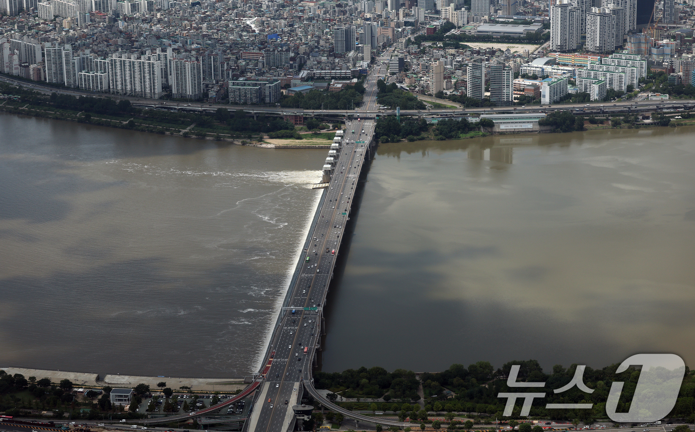 (서울=뉴스1) 오대일 기자 = 장마가 끝나고 폭염이 찾아온 23일 오후 서울 송파구 롯데월드타워 전망대 서울스카이에서 바라본 한강이 흙탕물로 변해 있다.   2025.7.23/뉴 …