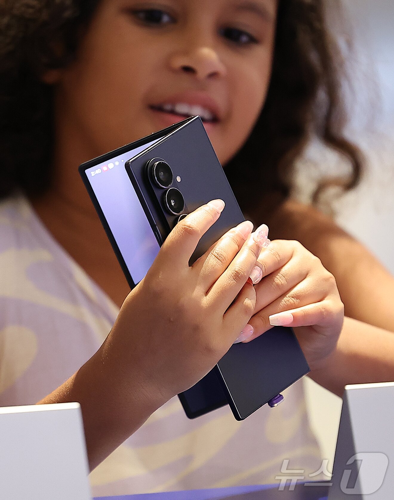 본문 이미지 - 23일 서울 영등포구 여의도 더현대 서울에 마련된 갤럭시 스튜디오에서 한 외국인 어린이가 진열된 갤럭시Z 폴드7을 살펴보고 있다. 2025.7.23/뉴스1 ⓒ News1 김진환 기자