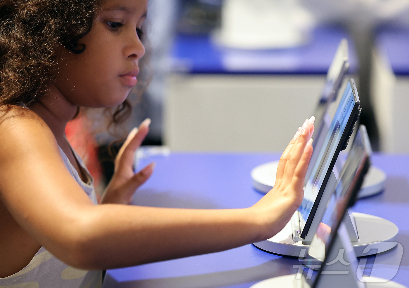 (서울=뉴스1) 김진환 기자 = 23일 서울 영등포구 여의도 더현대 서울에 마련된 갤럭시 스튜디오에서 한 외국인 어린이가 진열된 갤럭시Z 폴드7을 살펴보고 있다.삼성전자는 최근 공 …