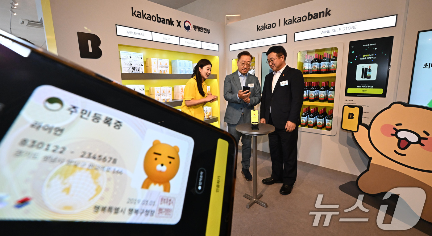 (서울=뉴스1) 김성진 기자 = 윤호중 행정안전부 장관이 23일 서울 성동구 앤더슨씨에서 열린 2025년 모바일 신분증 민간개방 오픈 행사에서 윤호영 카카오뱅크 대표와 카카오뱅크 …