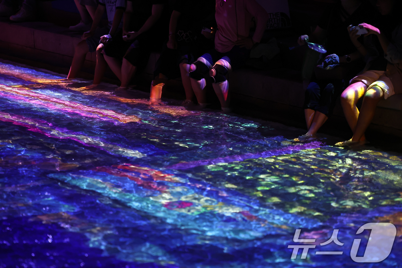 (서울=뉴스1) 김도우 기자 = 무더위가 이어진 23일 서울 중구 청계천을 찾은 시민들이 수면 미디어아트를 보며 더위를 식히고 있다. 2025.7.23/뉴스1