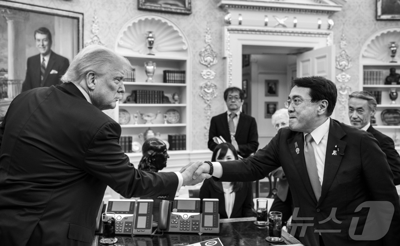 (서울=뉴스1) 김진환 기자 = 도널드 트럼프 미국 대통령이 백악관 집무실에서 23일(현지시간) 아카자와 료세이 일본 경제재생상과 양국 무역협상을 타결 후 악수를 하고 있다. (댄 …