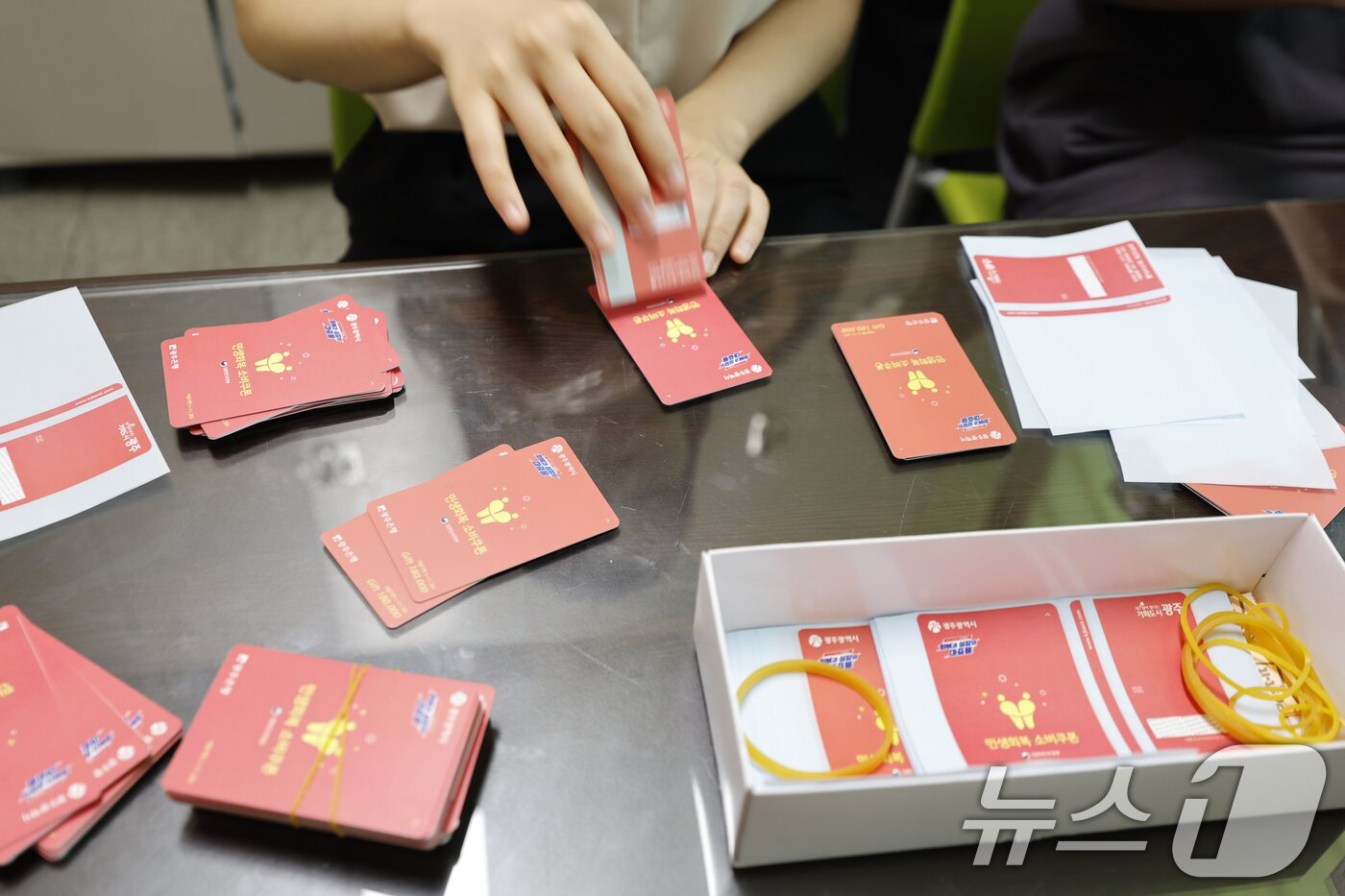 본문 이미지 - 광주시가 민생 회복 소비쿠폰 선불카드의 액수별 '카드 색상'을 다르게 배부해 논란이 인 가운데 24일 광주 한 행정복지센터에서 공직자들이 선불카드에 스티커 부착 작업을 하고있다. 2025.7.24/뉴스1 ⓒ News1 김태성 기자