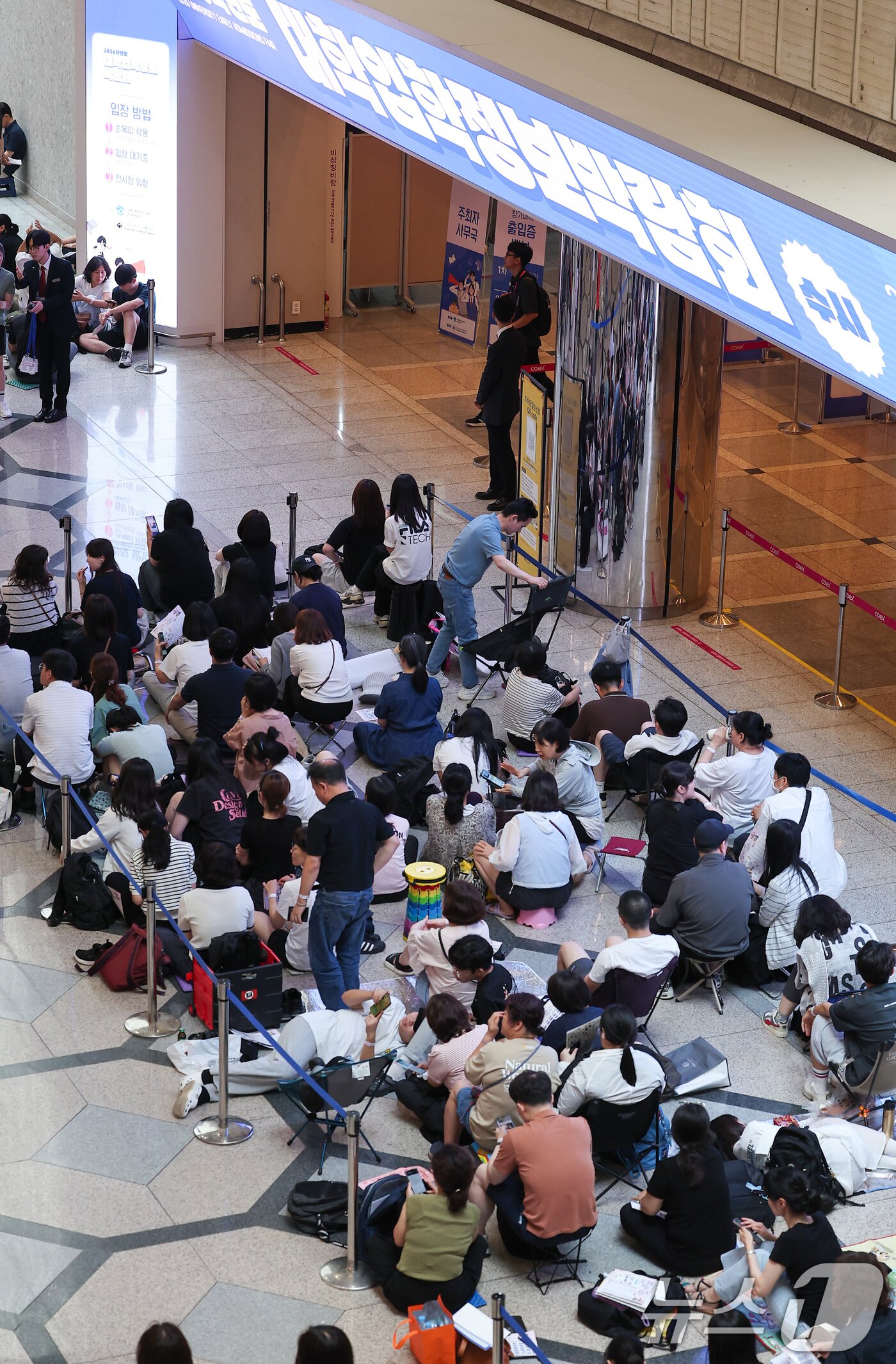 본문 이미지 - 24일 서울 강남구 삼성동 코엑스에서 열린 2026학년도 수시대학입학정보박람회를 찾은 수험생과 학부모들이 입장을 기다리고 있다. 2025.7.24/뉴스1 ⓒ News1 김성진 기자