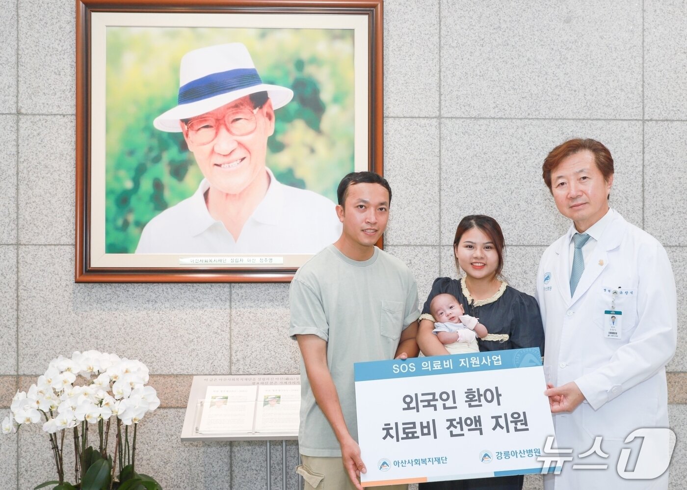 본문 이미지 - 유창식 병원장과 환아의 가족이 고(故) 정주영 아산사회복지재단 설립자의 사진 앞에서 기념촬영을 하고 있다.(강릉아산병원 제공, 재판매 및 DB 금지) 2025.7.24/뉴스1