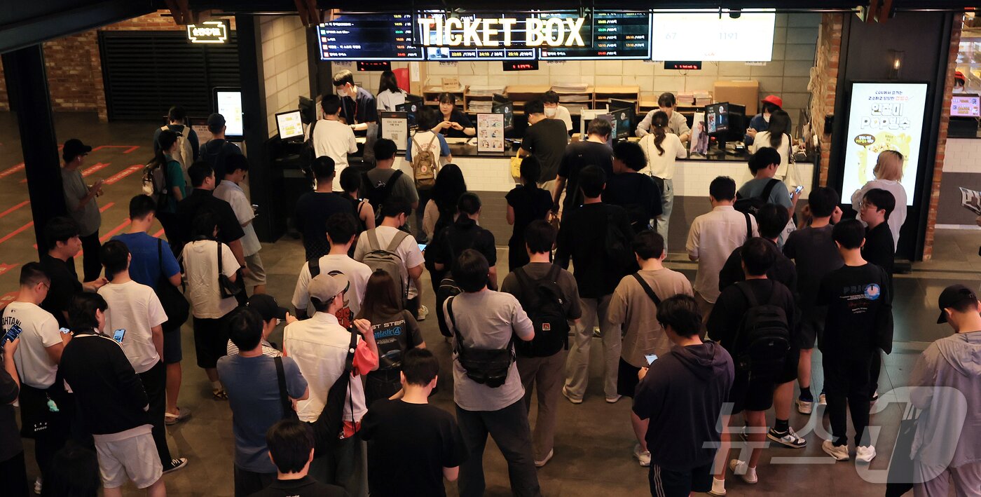 본문 이미지 - 7월 24일 서울 시내 한 영화관을 찾은 시민들이 한정판 굿즈를 받기 위해 매표소에서 줄 서서 기다리고 있다. 2025.7.24/뉴스1 ⓒ News1 김진환 기자