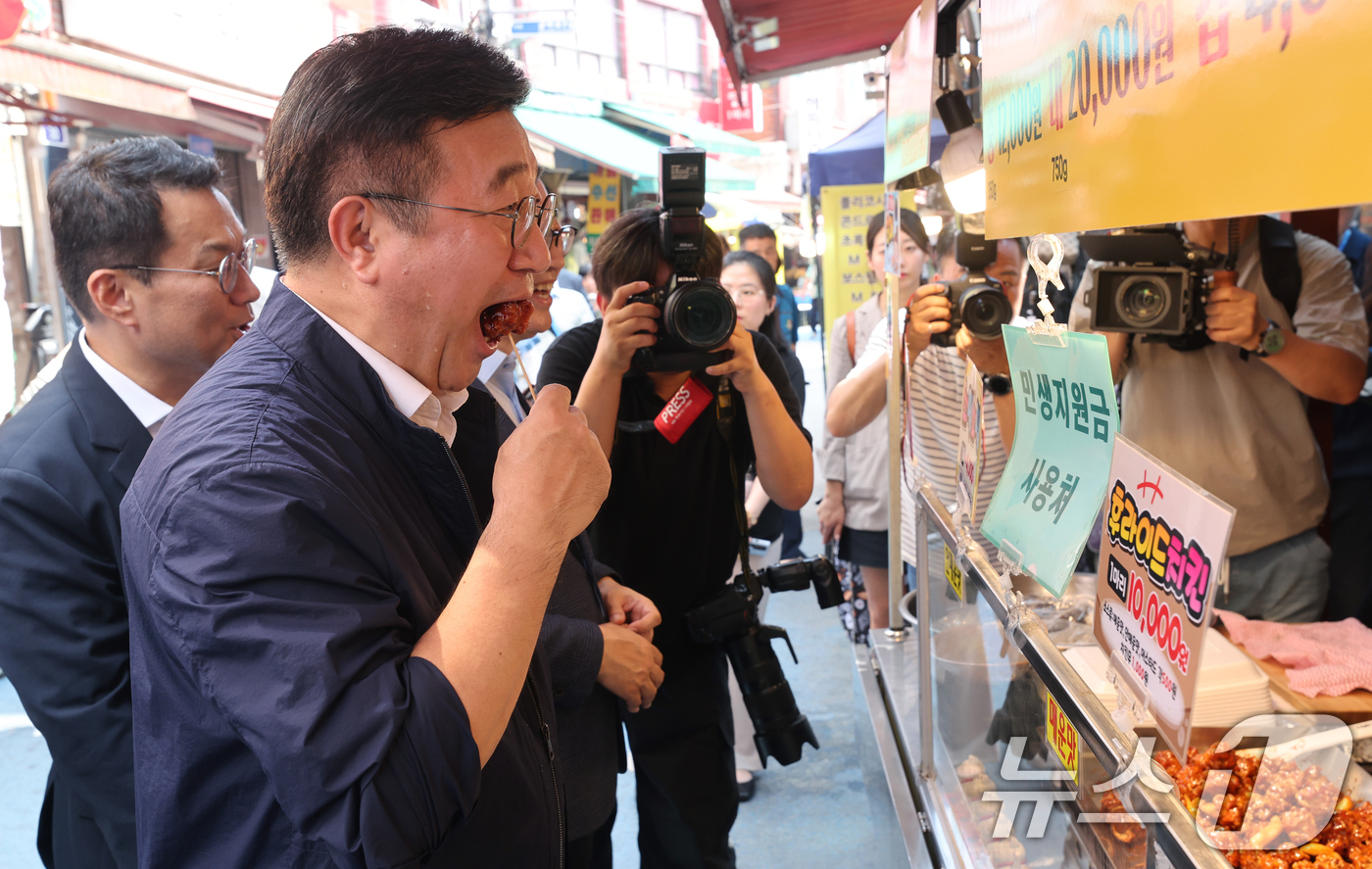 (서울=뉴스1) 오대일 기자 = 윤호중 행정안전부 장관이 24일 오후 민생회복 소비쿠폰 현장 점검차 서울 금천구 비단길 현대시장을 찾아 닭강정을 시식하고 있다. (공동취재) 202 …