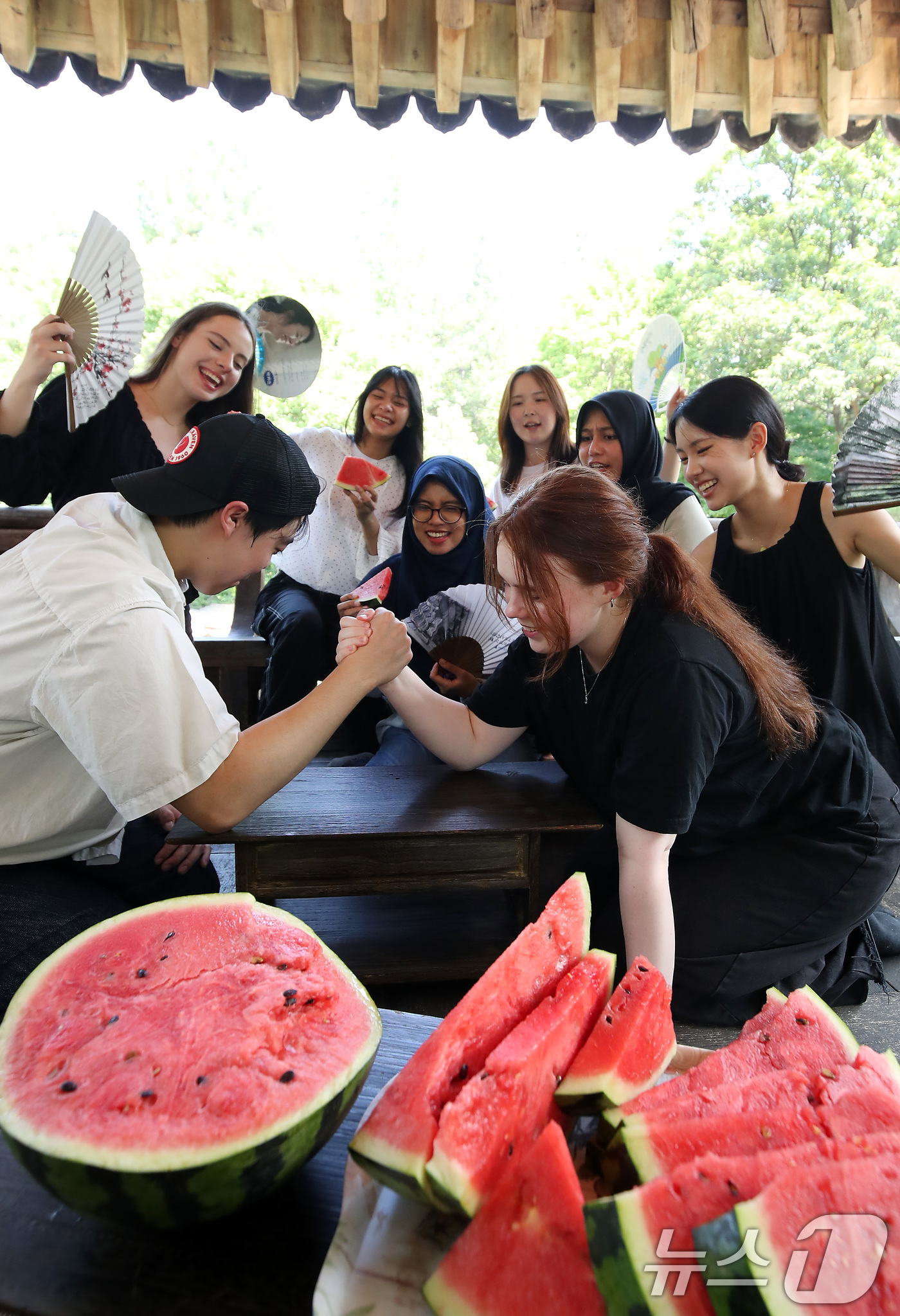 (대구=뉴스1) 공정식 기자 = 연일 폭염이 기승을 부린 24일 오후 대구 달서구 계명대 성서캠퍼스 한학촌에서 열린 '외국인 유학생 여름나기' 행사에 참여한 학생들이 수박을 앞에 …
