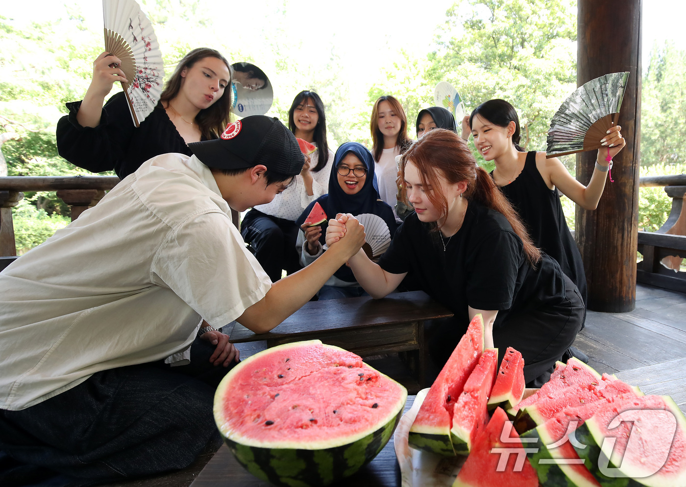 (대구=뉴스1) 공정식 기자 = 연일 폭염이 기승을 부린 24일 오후 대구 달서구 계명대 성서캠퍼스 한학촌에서 열린 '외국인 유학생 여름나기' 행사에 참여한 학생들이 수박을 앞에 …
