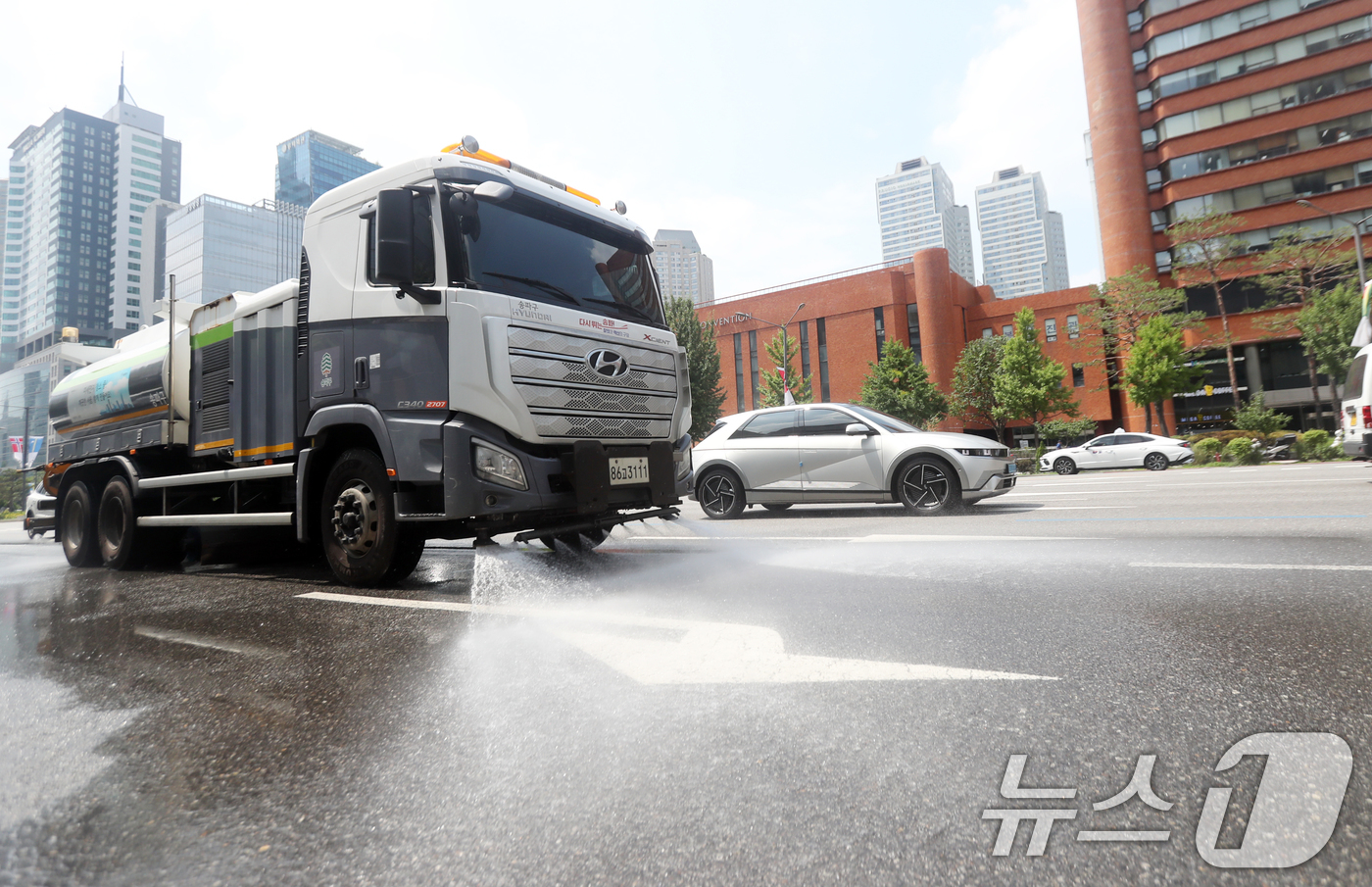 (서울=뉴스1) = 낮 최고기온이 34도까지 오른 24일, 서울 송파구 올림픽로 일대에 열기를 식히기 위한 살수차가 시원하게 물을 뿌리고 있다.송파구는 최근 지속되는 폭염으로 인한 …