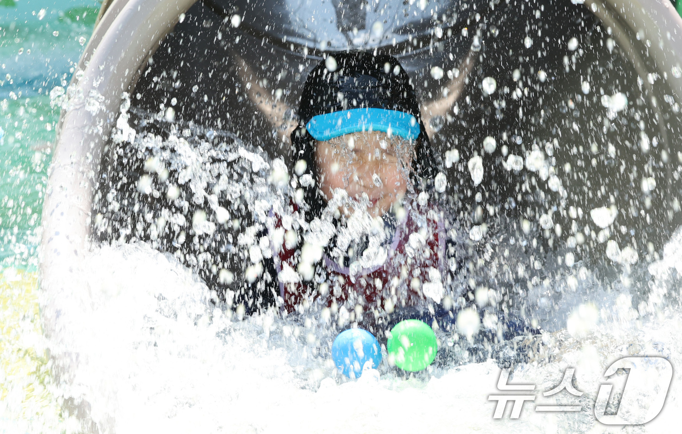 (서울=뉴스1) 장수영 기자 = 전국 대부분 지역에 폭염특보가 내려진 25일 오전 서울 종로구 연지물놀이터를 찾은 어린이가 물놀이를 하며 더위를 식히고 있다. 2025.7.25/뉴 …