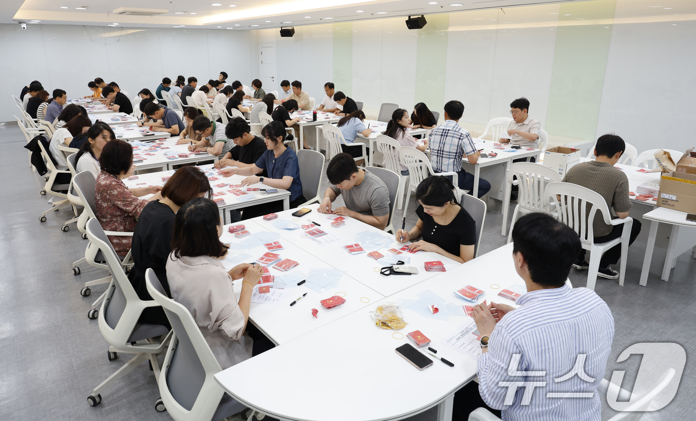 (광주=뉴스1) 김태성 기자 = 민생회복 소비쿠폰 카드를 소득수준에 따라 다른 색으로 지급한 광주시가 뒷수습에 나선 가운데 25일 시청 중회의실 등에서 공무원이 카드에 스티커를 덧 …