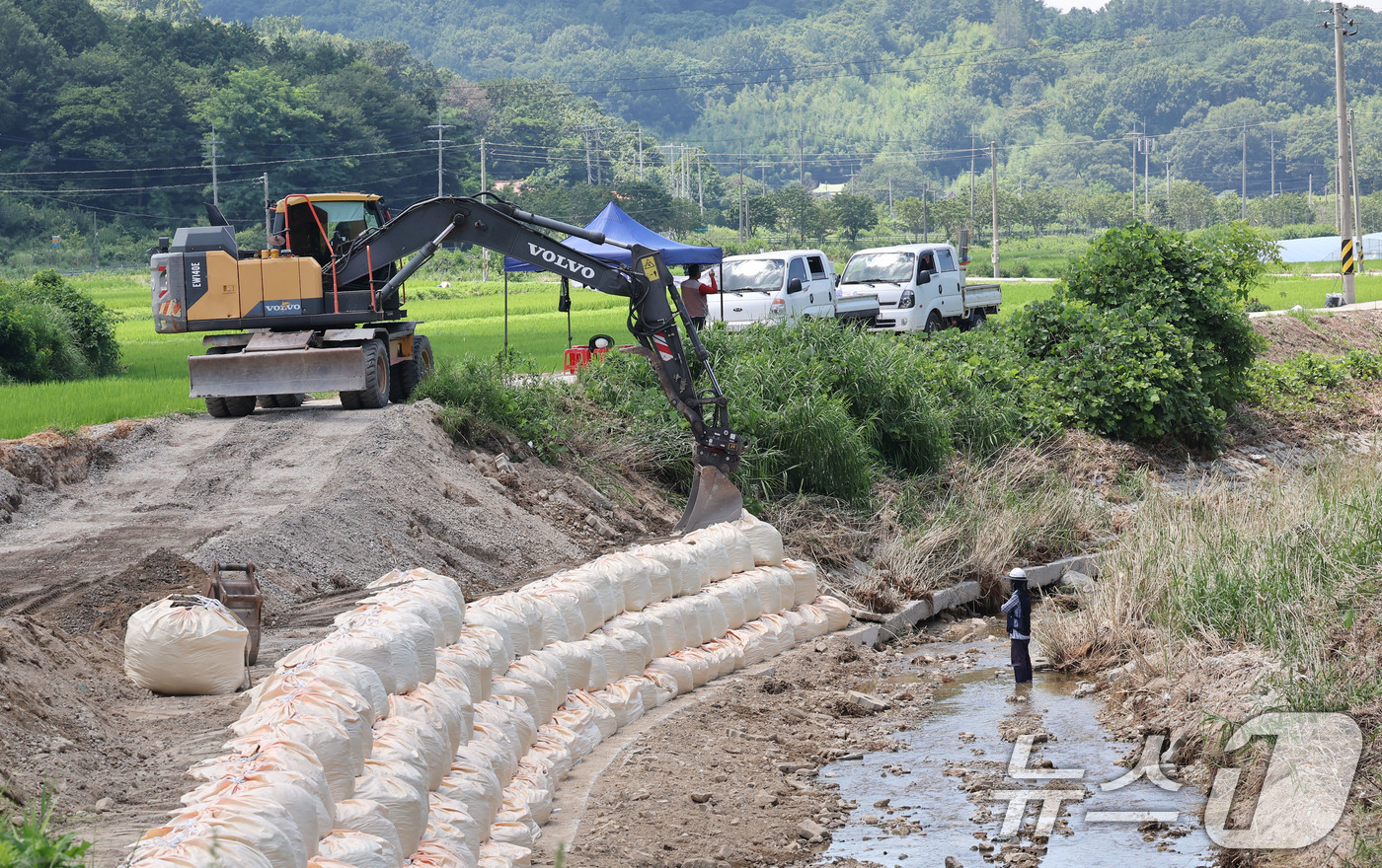 (광주=뉴스1) 박지현 기자 = 폭염경보가 내려진 25일 현장관계자들이 폭우로 무너진 전남 담양군 금성면 가사 소하천의 제방을 다시 쌓아올리고 있다. 2025.7.25/뉴스1