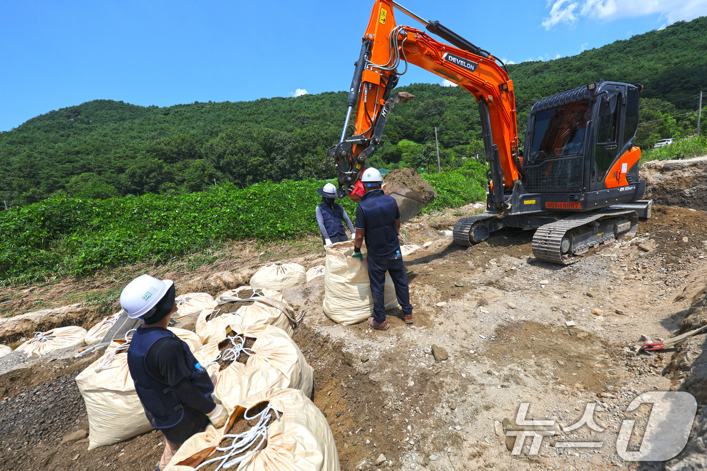 (광주=뉴스1) 박지현 기자 = 폭염경보가 내려진 25일 현장관계자들이 폭우로 무너진 전남 담양군 금성면 가사 소하천의 제방을 다시 쌓아올리고 있다. 2025.7.25/뉴스1