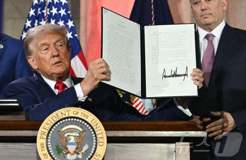 본문 이미지 - 23일&#40;현지시간&#41; 미국 워싱턴 D.C.의 앤드루 W. 멜론 오디토리움에서 열린 ‘AI 경쟁에서 승리하기&#40;Winning the AI Race&#41;’ 정상회의에서 도널드 트럼프 미국 대통령이 AI 관련 행정명령에 서명한 후 이를 공개했다. 이 행정명령은 미국이 글로벌 AI 경쟁에서 우위를 확보하기 위한 전략의 일환으로, 규제 완화와 기술 수출 확대 등을 포함하고 있다. ⓒ AFP=뉴스1