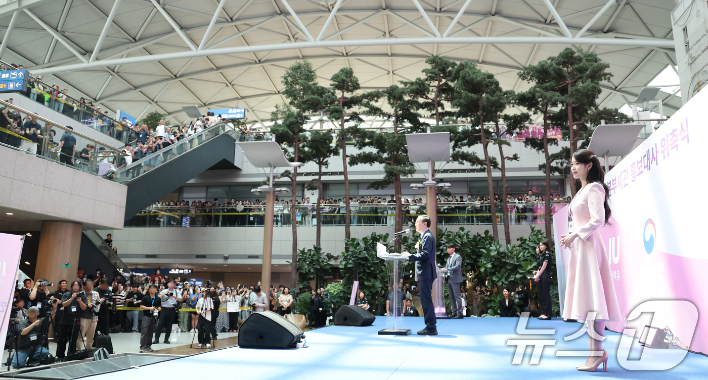 (인천공항=뉴스1) 권현진 기자 = 가수 겸 배우 아이유(오른쪽)가 25일 인천국제공항 제1여객터미널에서 열린 인천공항세관 홍보대사 위촉식에 참석해 이명구 관세청장의 축사를 경청하 …