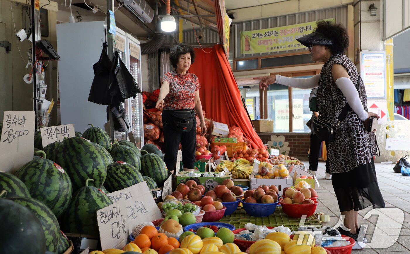 본문 이미지 - 전 국민에게 1인당 15만~45만원을 지급하는 '민생회복 소비쿠폰' 지급 첫 주말인 26일 광주 서구 양동시장에서 한 손님이 과일을 고르고 있다. 2025.7.26/뉴스1 ⓒ News1 이수민 기자