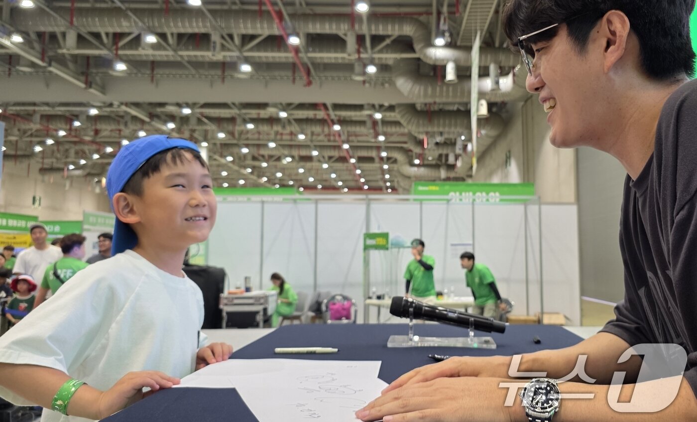 본문 이미지 - 26일 구미코에서 열린 대한민국 펫캉스에 참여한 한 어린이가 인기 유튜버 &#39;TV 생물도감&#39; 의 사인을 받은 뒤 기뻐하고 있다. 펫캉스는 오는 27일까지 열린다. 2025.7.26/뉴스1 ⓒ News1 정우용 기자