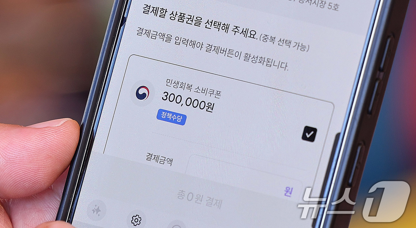 (서울=뉴스1) 박지혜 기자 = 민생회복 소비쿠폰 지급 이후 첫 주말인 27일 서울 동대문구 청량리종합시장을 찾은 한 시민이 민생회복 소비쿠폰을 사용하고 있다. 2025.7.27/ …