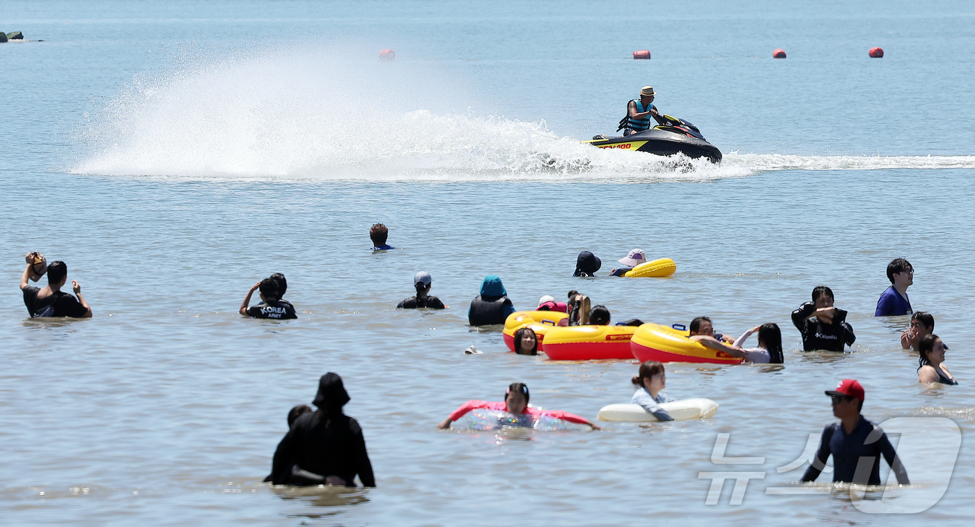 (인천=뉴스1) 김진환 기자 = 전국 대부분 지역에 폭염특보가 내려진 27일 오후 인천 중구 을왕리 해수욕장을 찾은 시민들이 더위를 식히고 있다. 2025.7.27/뉴스1