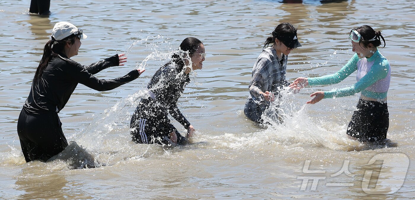 본문 이미지 - 전국 대부분 지역에 폭염특보가 내려진 27일 오후 인천 중구 을왕리 해수욕장을 찾은 시민들이 더위를 식히고 있다. 2025.7.27/뉴스1 ⓒ News1 김진환 기자