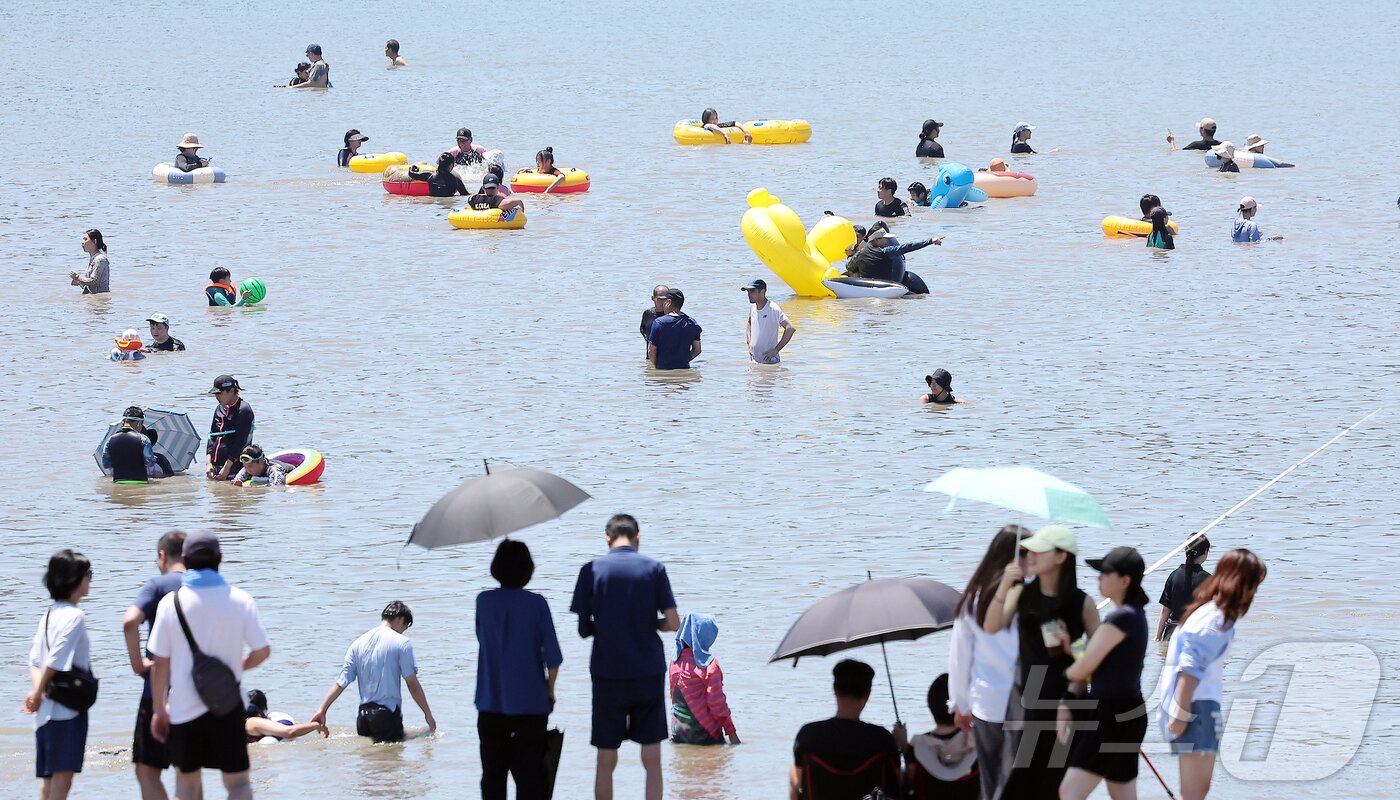 본문 이미지 - 전국 대부분 지역에 폭염특보가 내려진 27일 오후 인천 중구 을왕리 해수욕장을 찾은 시민들이 더위를 식히고 있다. 2025.7.27/뉴스1 ⓒ News1 김진환 기자
