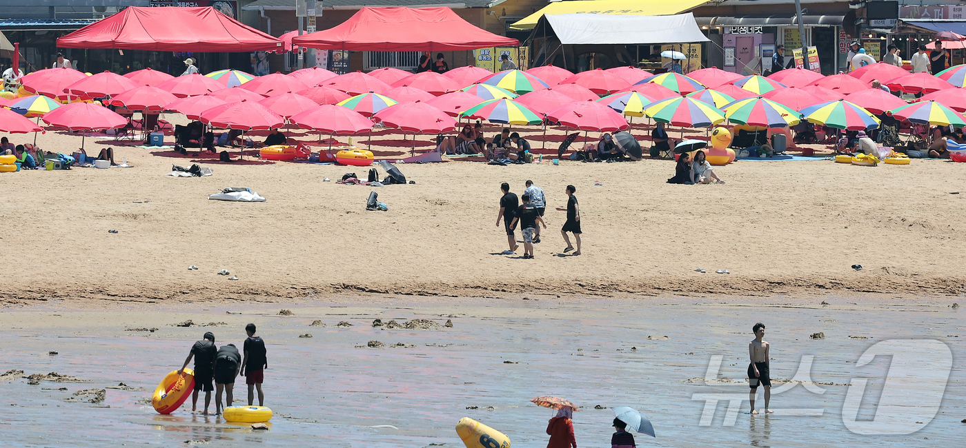 (인천=뉴스1) 김진환 기자 = 전국 대부분 지역에 폭염특보가 내려진 27일 오후 인천 중구 을왕리 해수욕장을 찾은 시민들이 더위를 식히고 있다. 2025.7.27/뉴스1