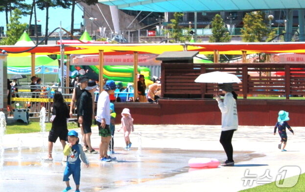 본문 이미지 - 27일 정오께 전북 전주월드컵경기장광장에 마련된 '한바탕 전주 여름철 물놀이장' 옆 바닥분수에서 아이들이 무더위를 피하고 있. 2025.7.27/뉴스1 신준수 기자