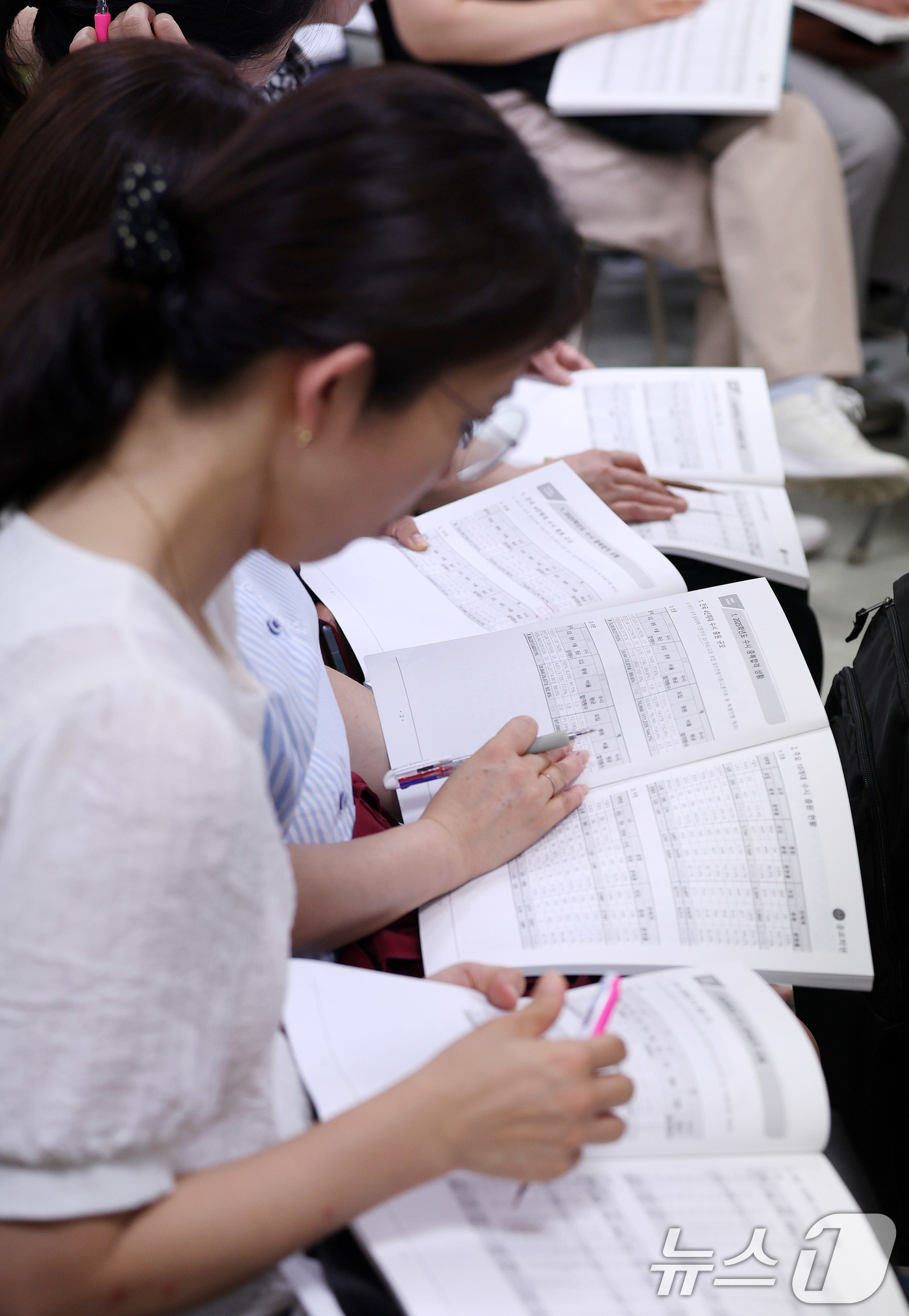 (서울=뉴스1) 박지혜 기자 = 27일 서울 강남구 대치동 강남종로학원 대강당에서 열린 ‘2026 수시·정시 대학 선택전략 특집 설명회’를 찾은 학부모들이 자료집을 살펴보고 있다. …